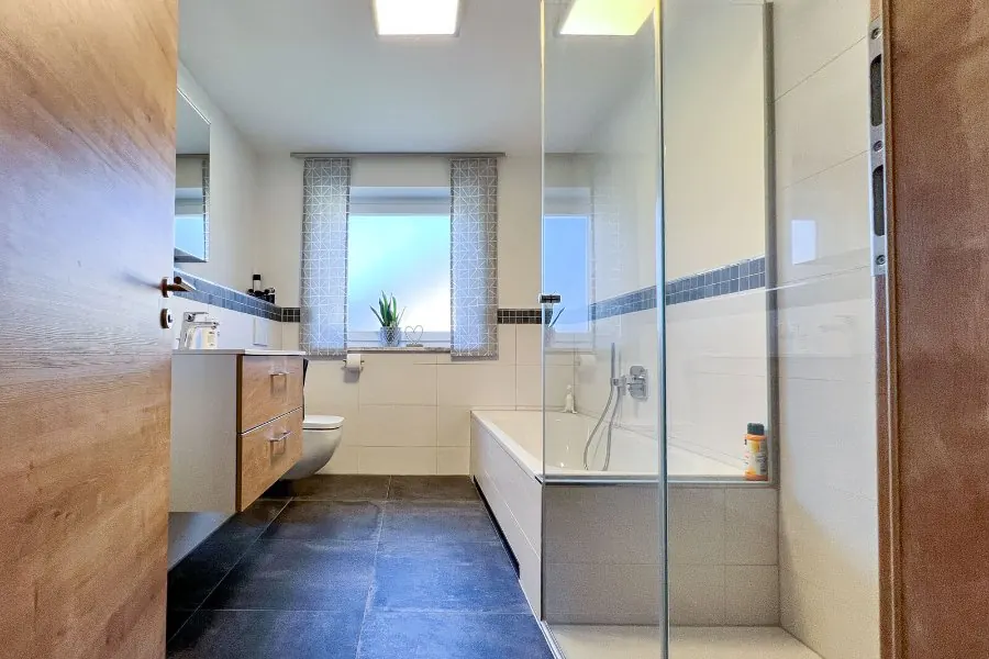 Renoviertes Bad mit Glasdusche und Badewanne in Neureichenau